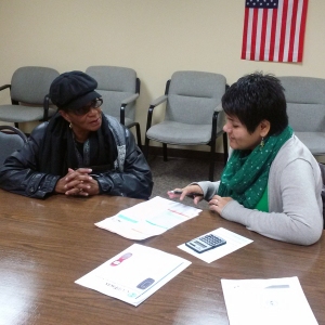 Ivonne, right, working with another consumer at a phone-bill clinic earlier this year. 